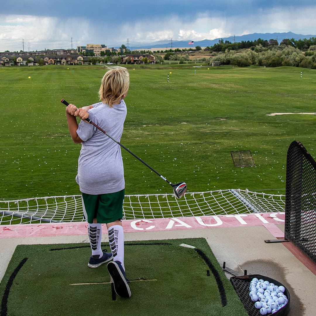 person golfing at the mulligans driving range