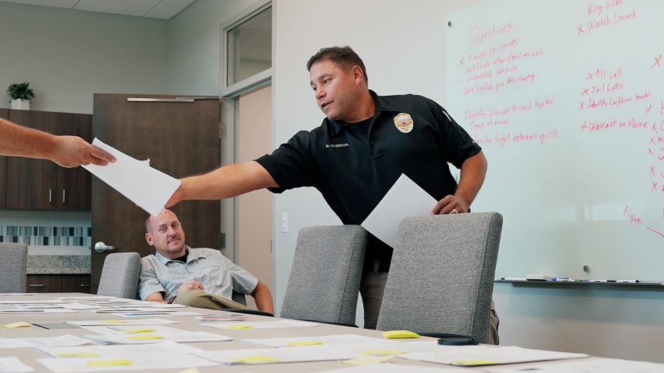 Detectives working on a case in the office by sorting through information and papers